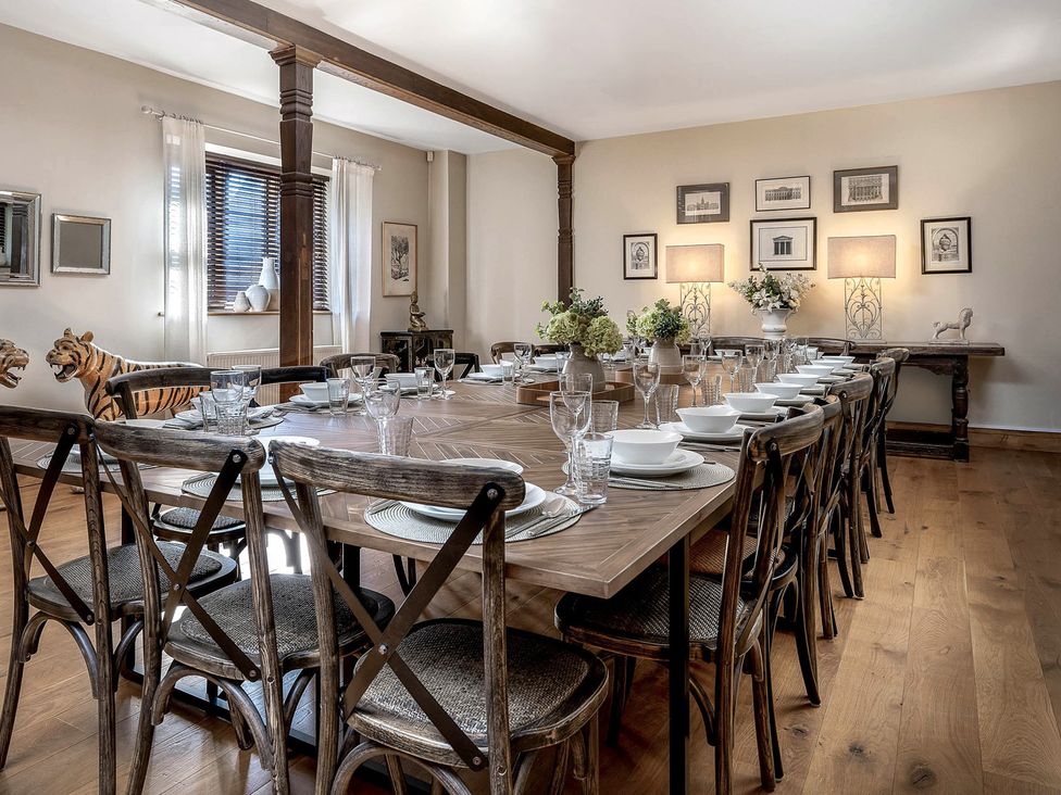 A dining room with a long table set for a meal at The Lady Rothschild Stables in Peterborough