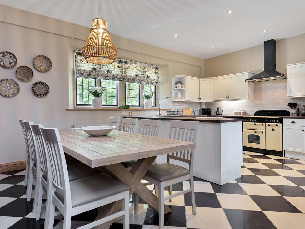 A kitchen with a dining table and chairs at The Lady Rothschild Stables in Peterborough