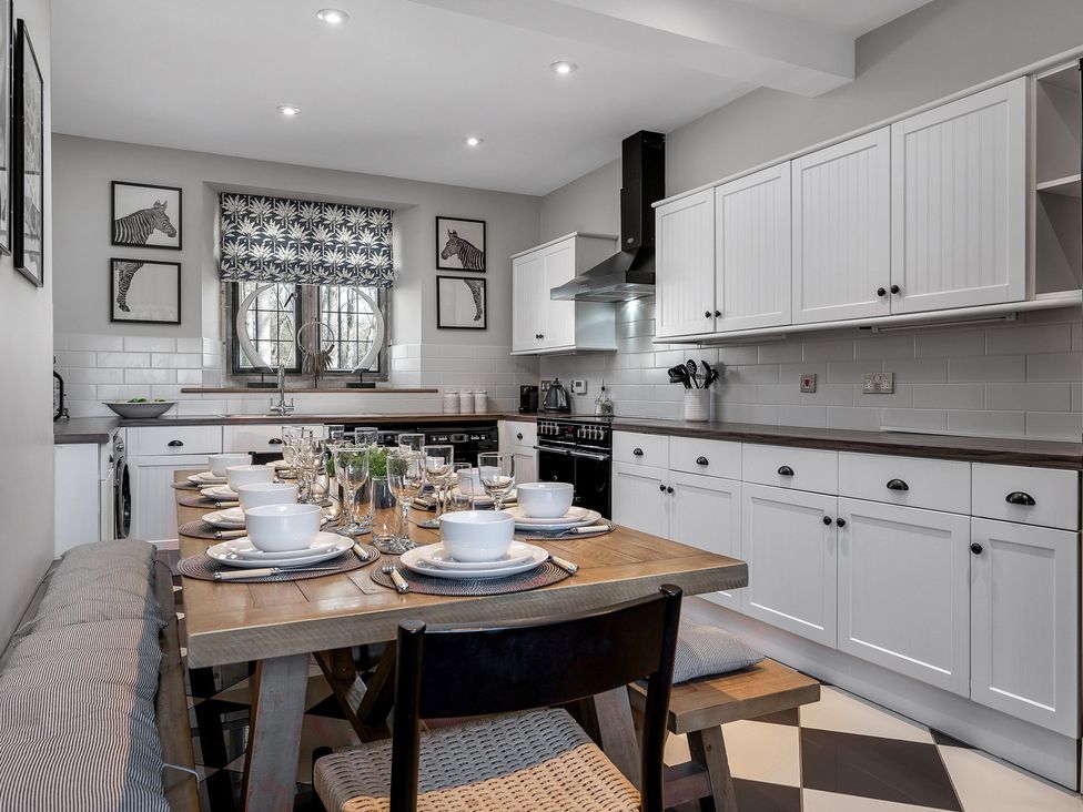 A kitchen with a dining table set for a meal at The Lady Rothschild Stables in Peterborough