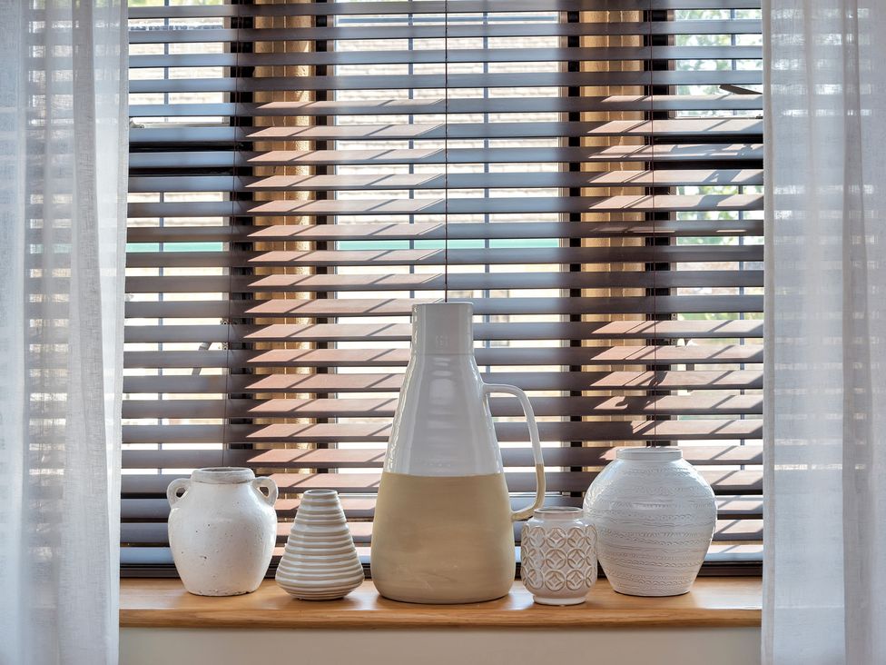 A collection of decorative vases on a window sill at The Lady Rothschild Stables in Peterborough