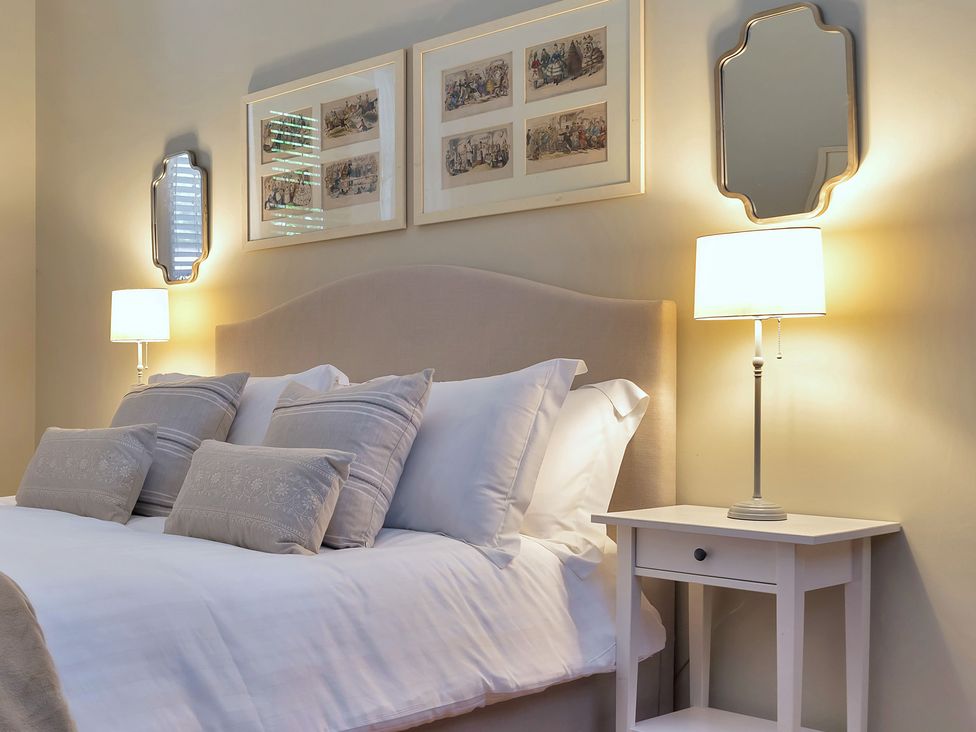 A bedroom with a bed and bedside table at The Lady Rothschild Stables in Peterborough