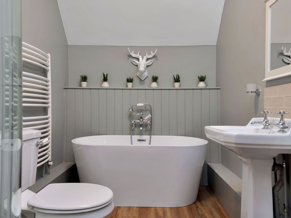 A bathroom with a bathtub, toilet, and sink at The Lady Rothschild Stables in Peterborough