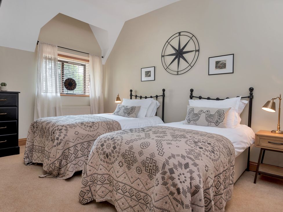 A bedroom with two beds and a window at The Lady Rothschild Stables in Peterborough