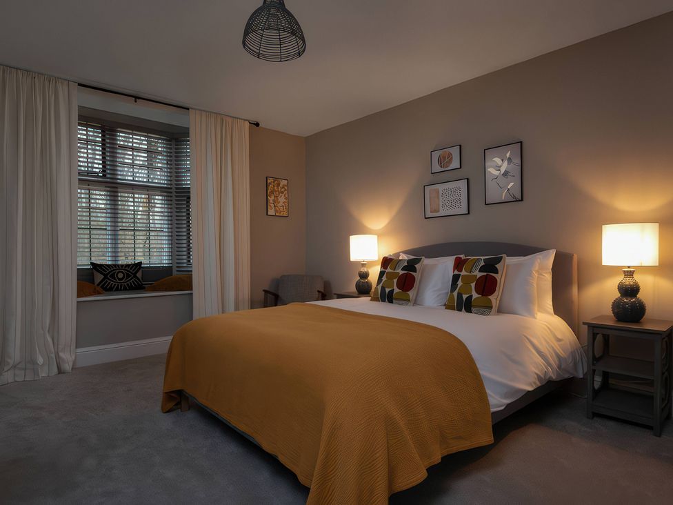 A bedroom with a bed, nightstands, and artwork at The Lady Rothschild Stables in Peterborough