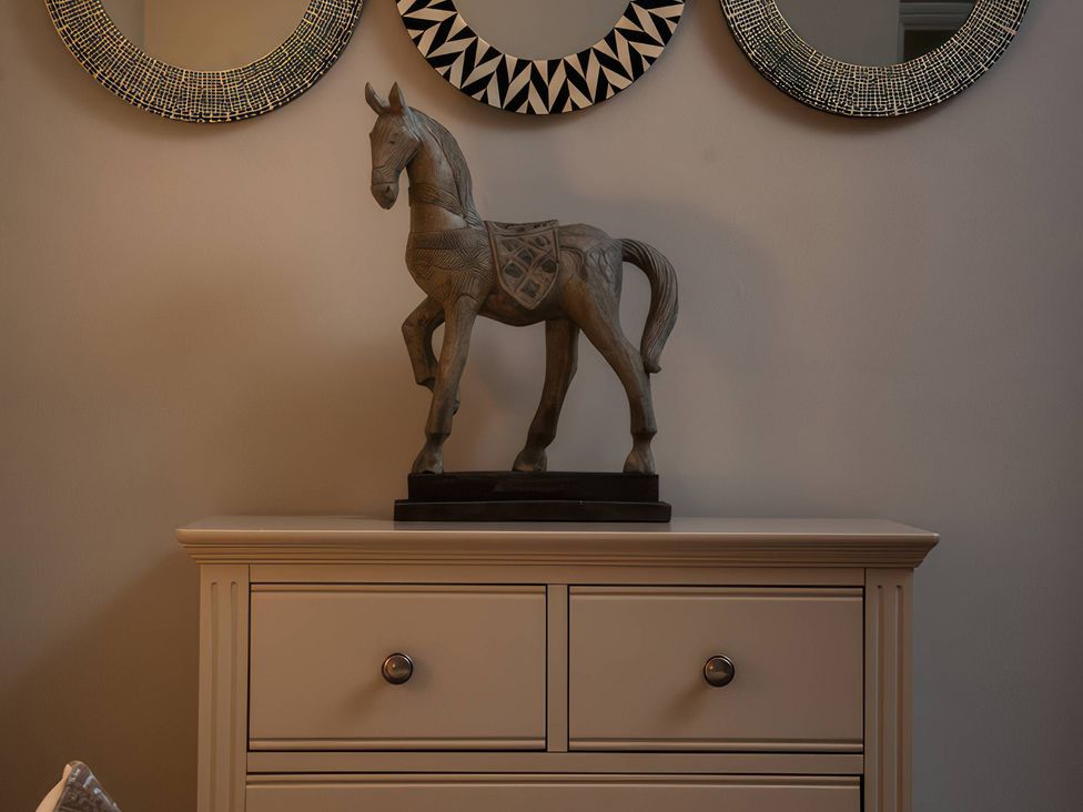 A horse statue on a chest of drawers with mirrors above at The Lady Rothschild Stables in Peterborough