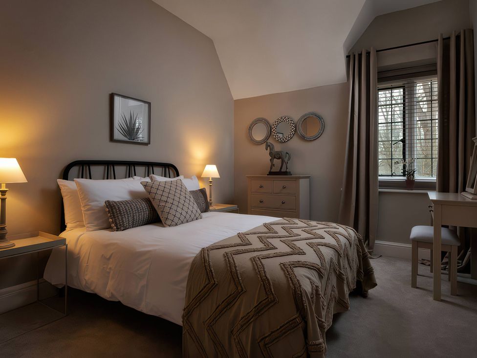 A bedroom with a bed and a dresser at The Lady Rothschild Stables in Peterborough