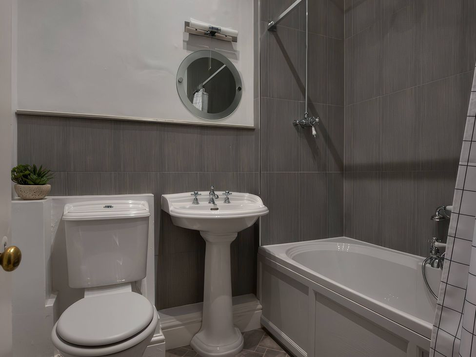 A bathroom with a bathtub, toilet, and sink at The Lady Rothschild Stables in Peterborough