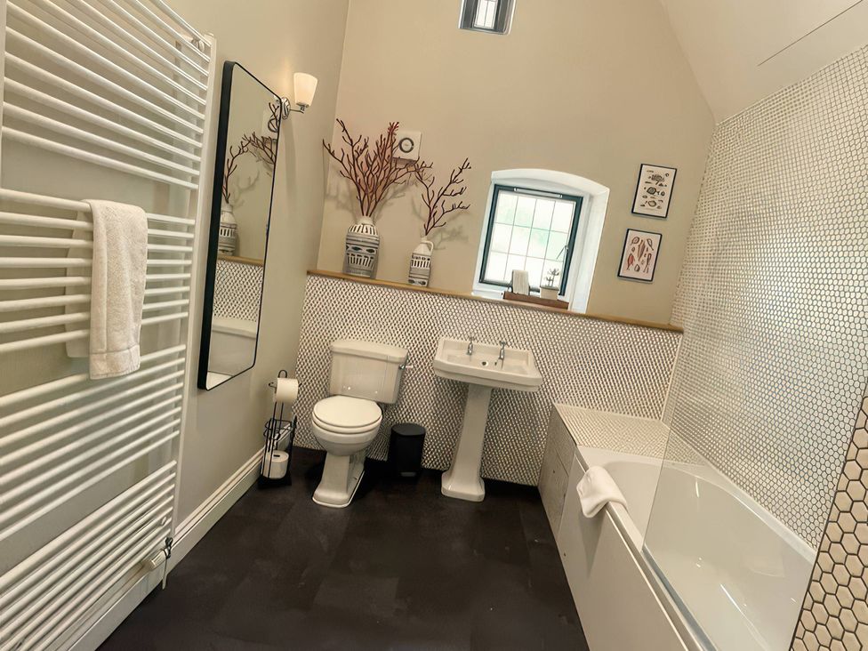 A bathroom with a sink, toilet and bathtub at The Lady Rothschild Stables in Peterborough
