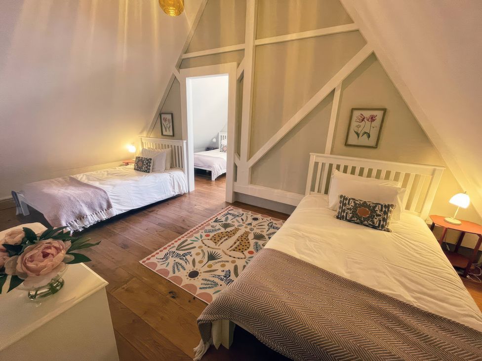 A bedroom with two beds and a rug at The Lady Rothschild Stables in Peterborough