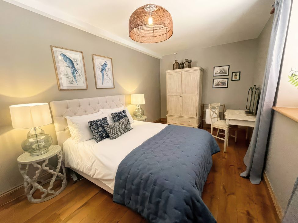A bedroom with a bed and desk at The Lady Rothschild Stables in Peterborough