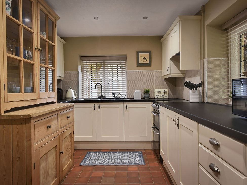 A kitchen with cabinets and a sink at Home Farm Cottage in Peterborough