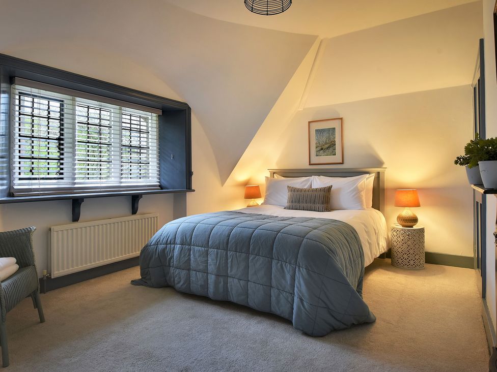 A bedroom with a bed and lamps at Home Farm Cottage Peterborough