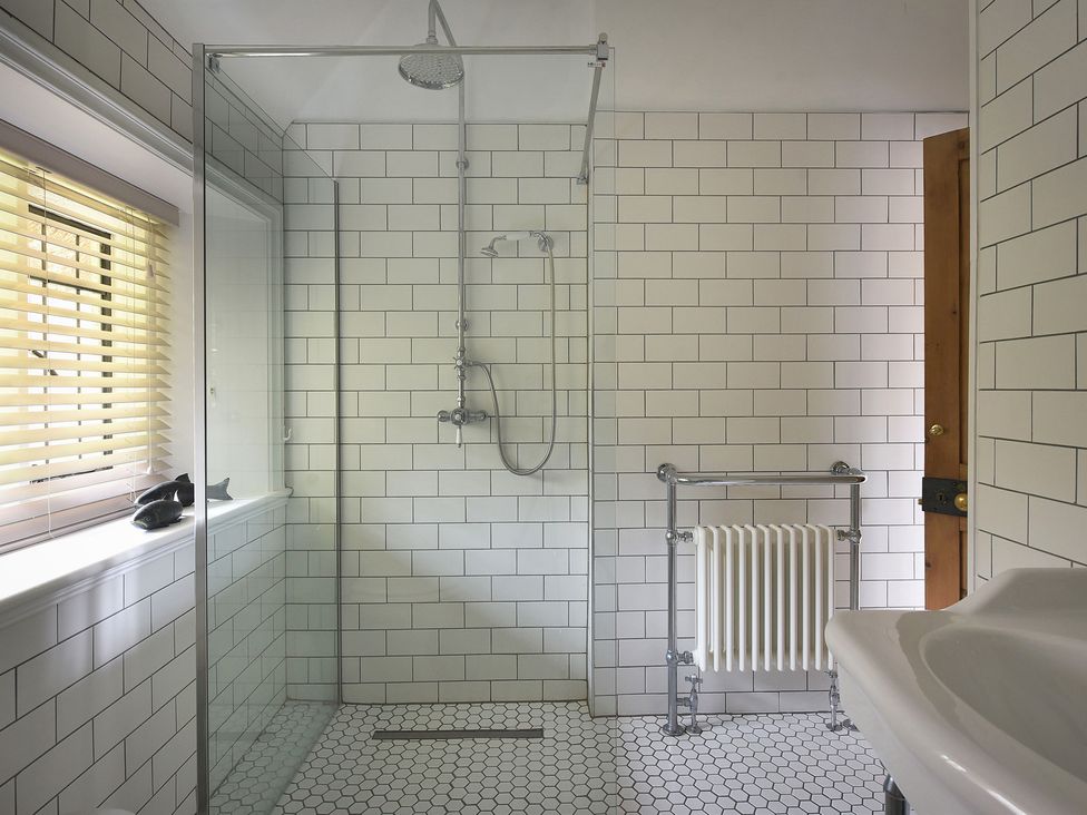A bathroom with a shower and a bathtub at Home Farm Cottage in Peterborough