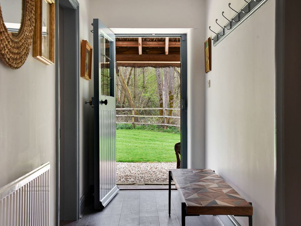 A hallway with a door leading to a garden at Home Farm Cottage in Peterborough