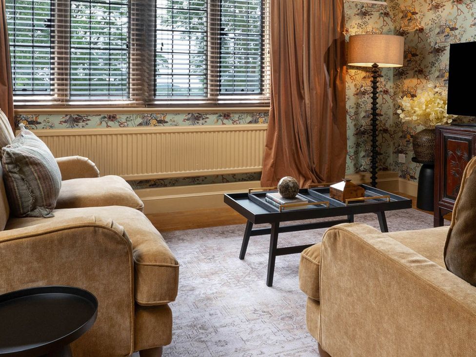 A living room with a sofa and coffee table at Rubens Rooms in Peterborough