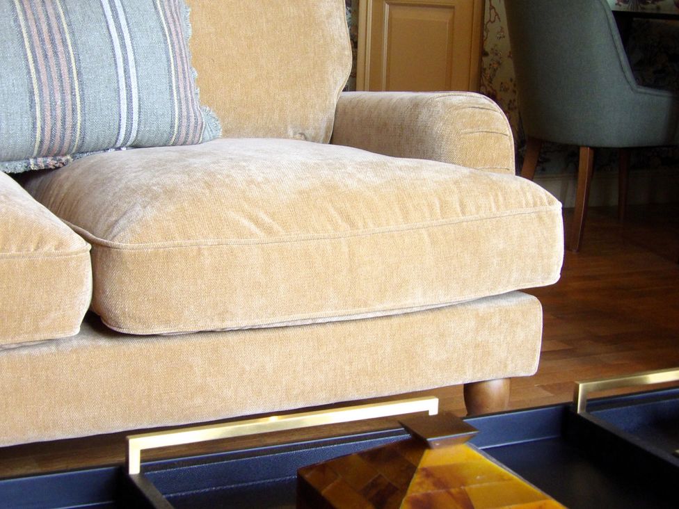 A sofa with a cushion and a coffee table at Rubens Rooms in Peterborough