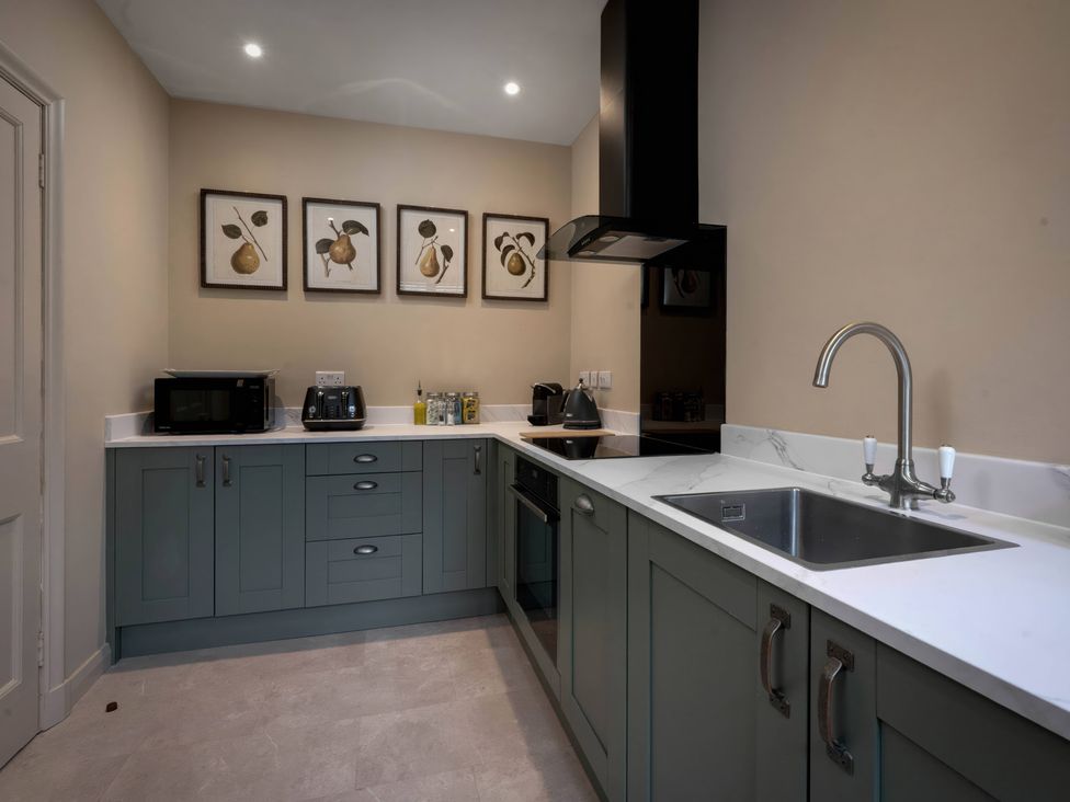 A kitchen with cabinets and appliances at Rubens Rooms in Peterborough