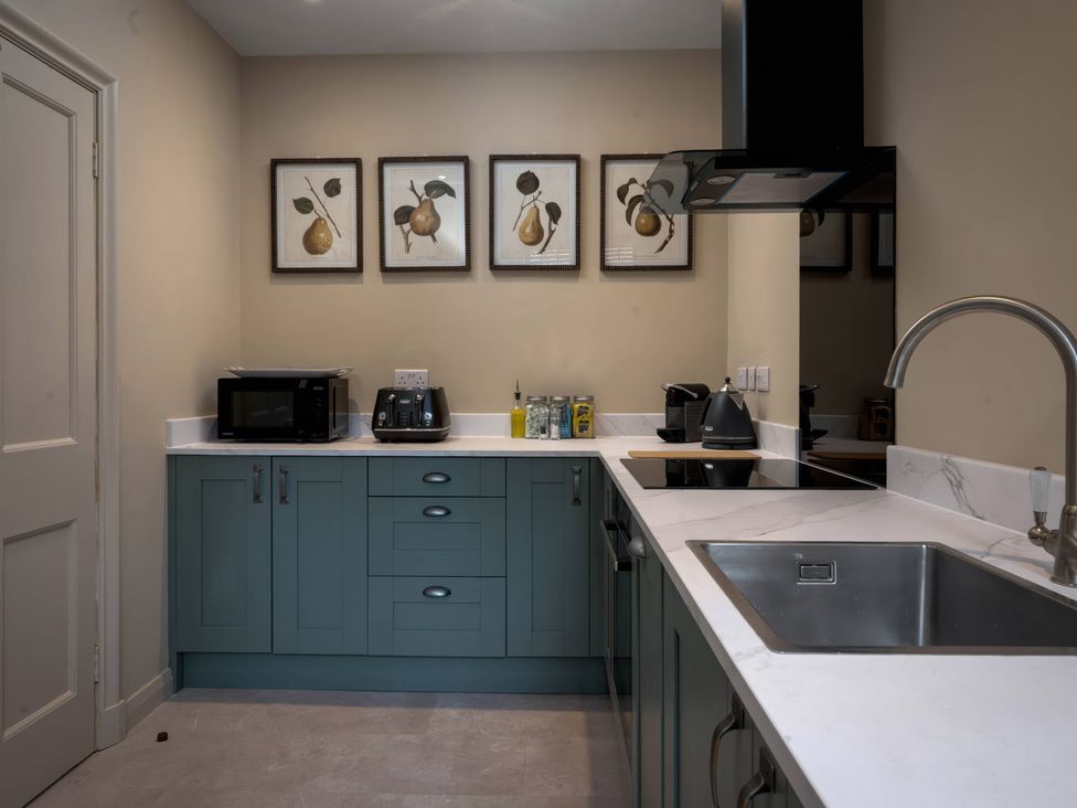 A kitchen with appliances and cabinets at Rubens Rooms in Peterborough