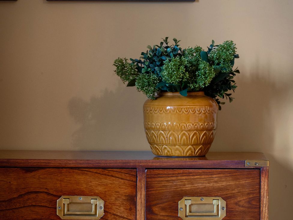 A plant in a pot on a wooden cabinet at Rubens Rooms in Peterborough