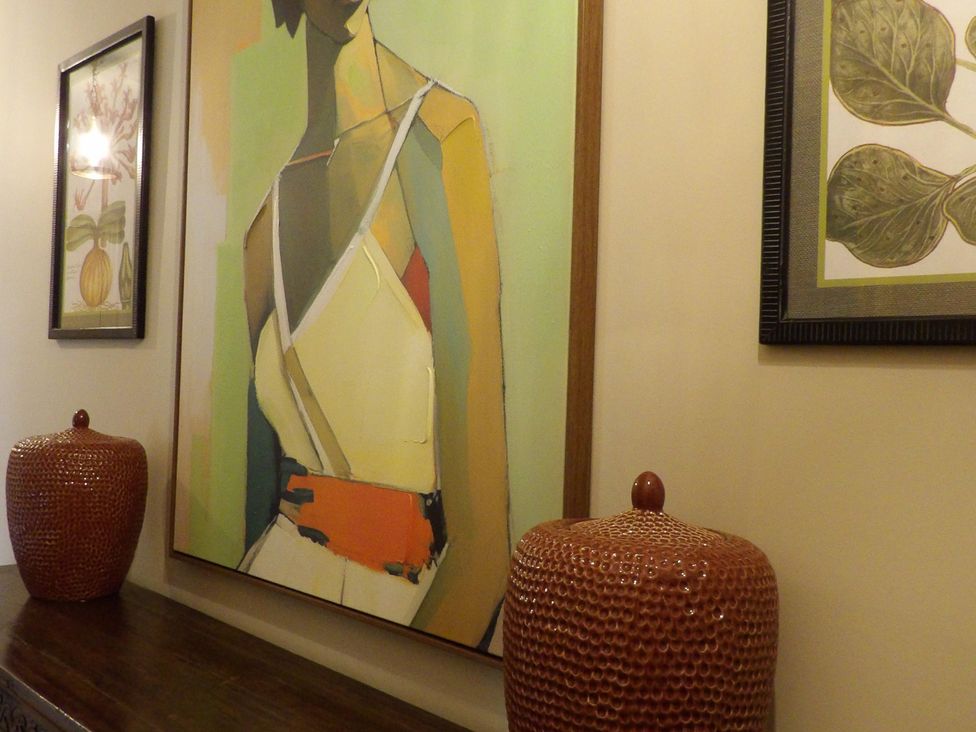A hallway featuring artwork and decorative vases at Rubens Rooms in Peterborough