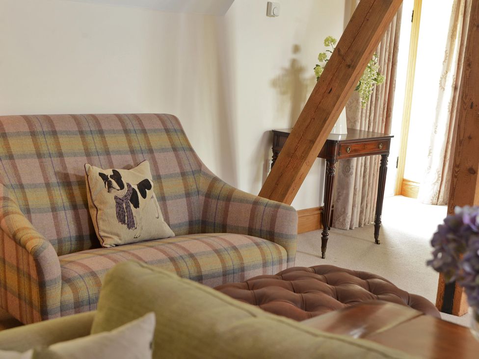 A living room with a sofa and table at The Lady Rothschild Dairy in Peterborough