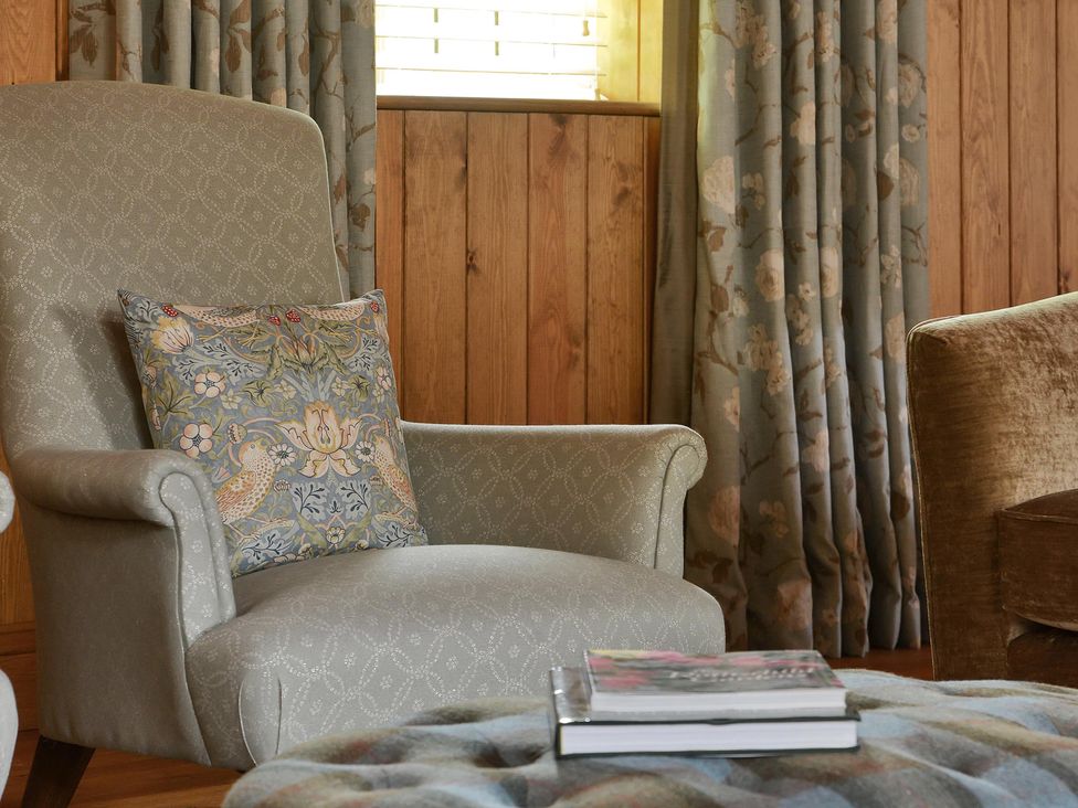 A living room with an armchair and cushion at The Lady Rothschild Dairy in Peterborough