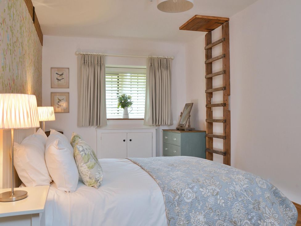 A bedroom with a bed and a ladder at The Lady Rothschild Dairy in Peterborough