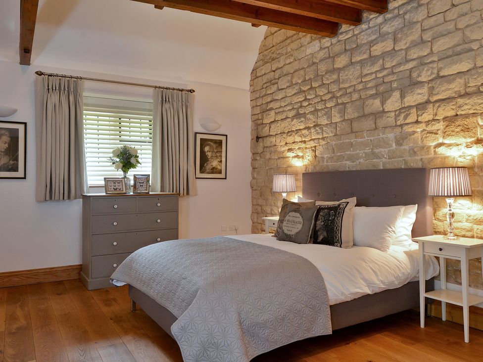 A bedroom featuring a bed with pillows and decorative items at The Lady Rothschild Dairy in Peterborough