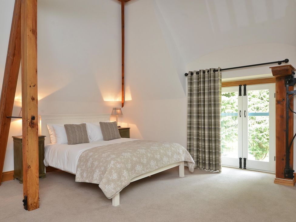 A bedroom with a bed and nightstands at The Lady Rothschild Dairy in Peterborough