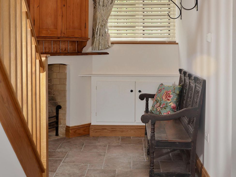 A hallway with a wooden bench and cabinets at The Lady Rothschild Dairy in Peterborough
