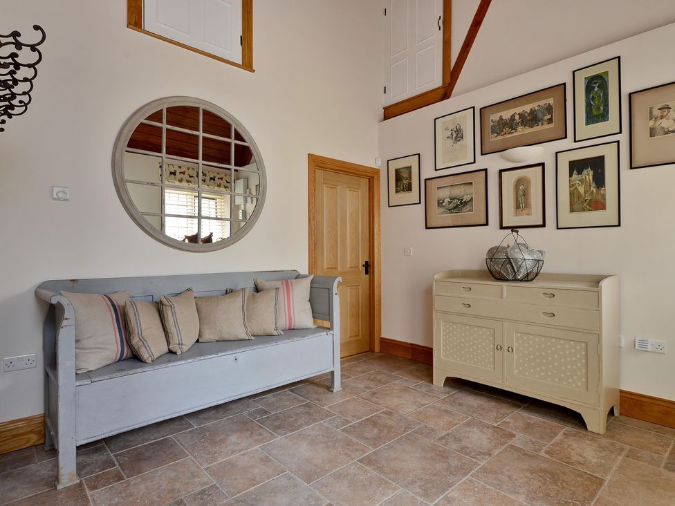 A hallway with a sofa and wall art at The Lady Rothschild Dairy in Peterborough