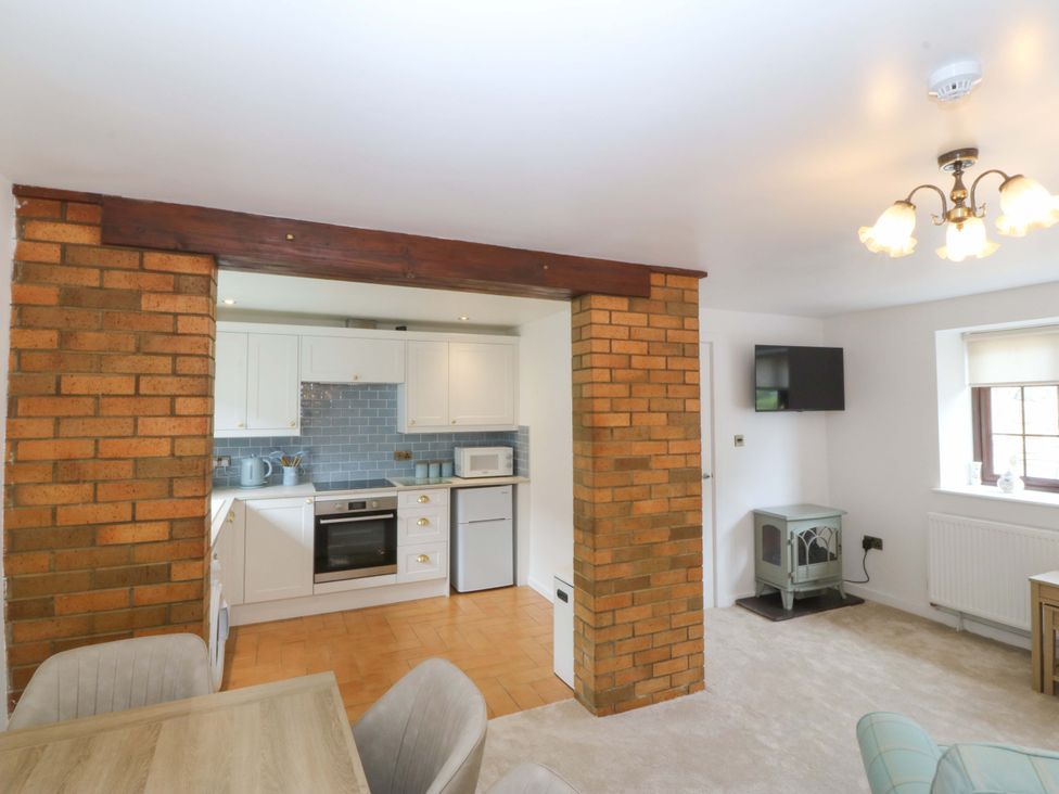 A kitchen with dining area and appliances at Cil Y Coed in Star near Llanfairpwllgwyngyll
