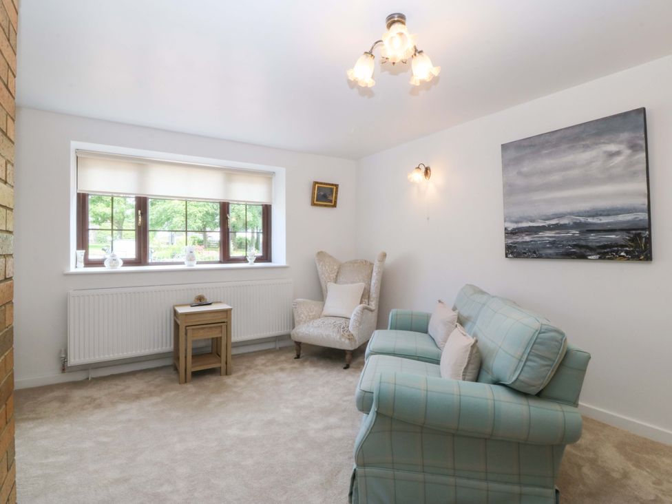 A living room with a sofa and armchair at Cil Y Coed in Star near Llanfairpwllgwyngyll