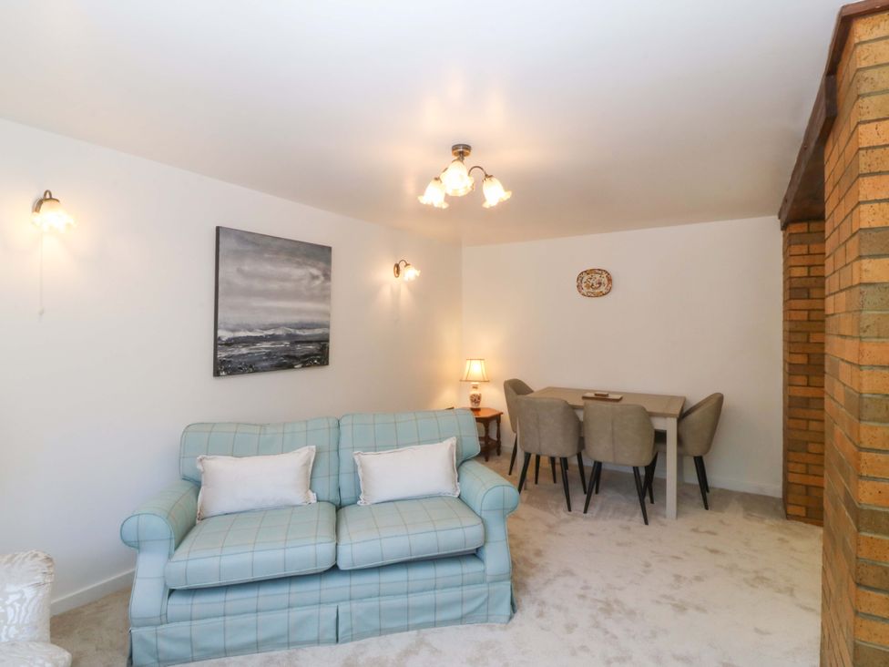 A living room with a sofa and dining area at Cil Y Coed in Star near Llanfairpwllgwyngyll