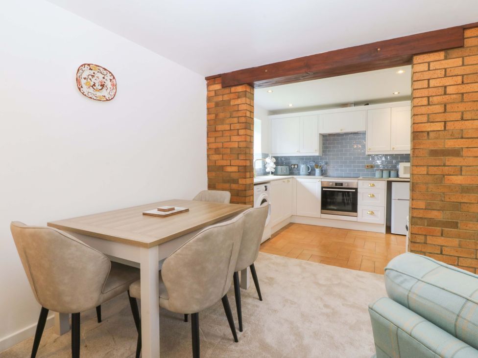 A dining area with a table and chairs adjacent to a kitchen at Cil Y Coed in Star near Llanfairpwllgwyngyll