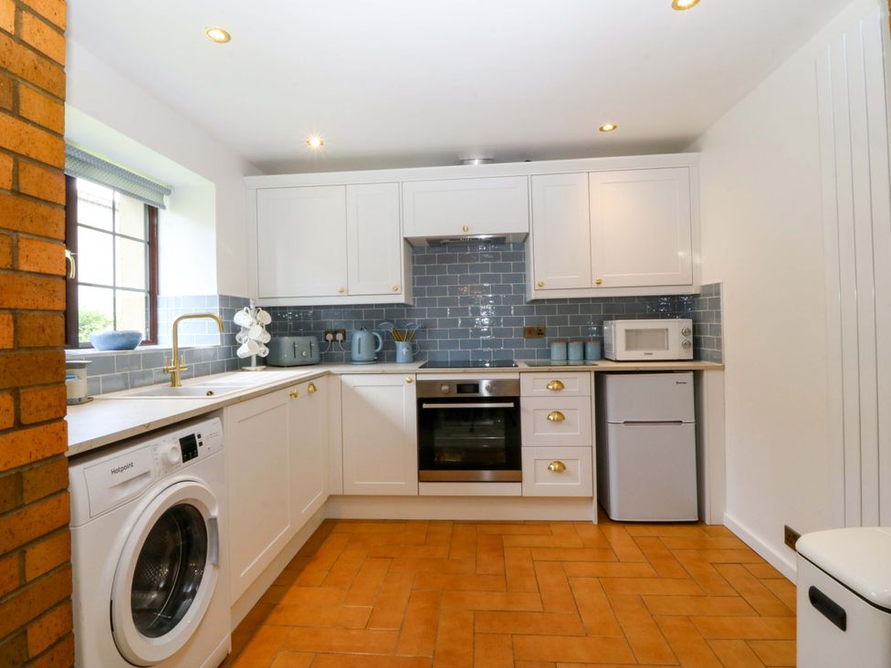 A kitchen with appliances including an oven and washing machine at Cil Y Coed near Star near Llanfairpwllgwyngyll