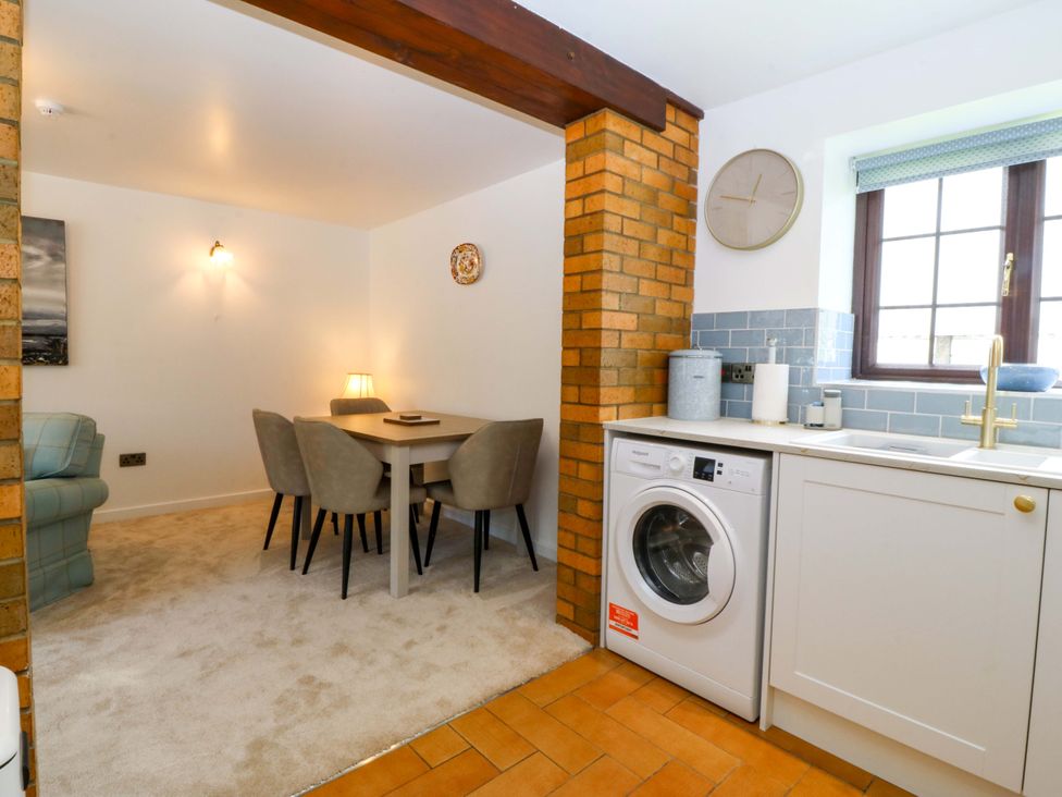 A kitchen/dining area with a washing machine and dining table at Cil Y Coed near Star near Llanfairpwllgwyngyll