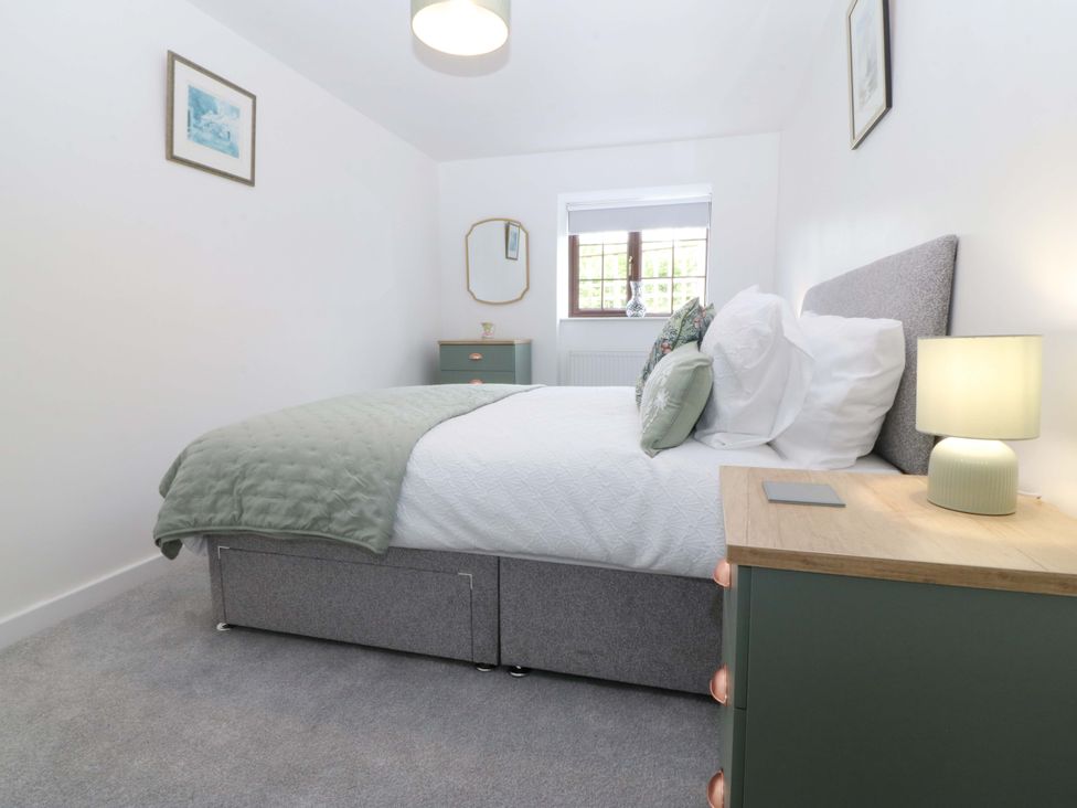A bedroom with a bed and bedside table at Cil Y Coed in Star near Llanfairpwllgwyngyll