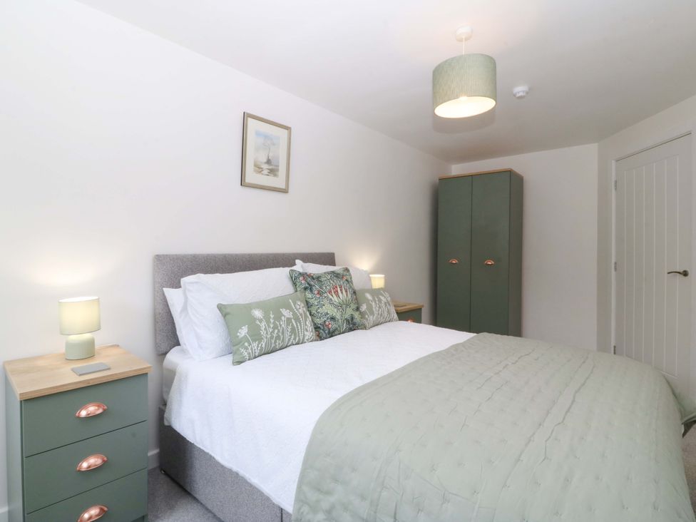 A bedroom with a bed and bedside table at Cil Y Coed in Star near Llanfairpwllgwyngyll