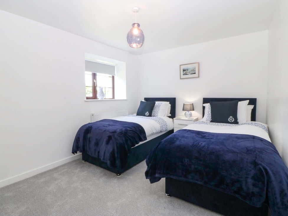 A bedroom with two beds and a window at Cil Y Coed in Star near Llanfairpwllgwyngyll