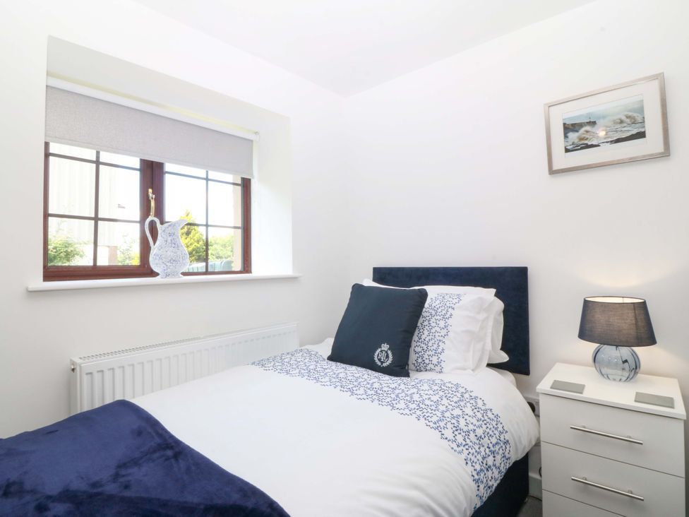 A bedroom with a bed and window at Cil Y Coed in Star near Llanfairpwllgwyngyll