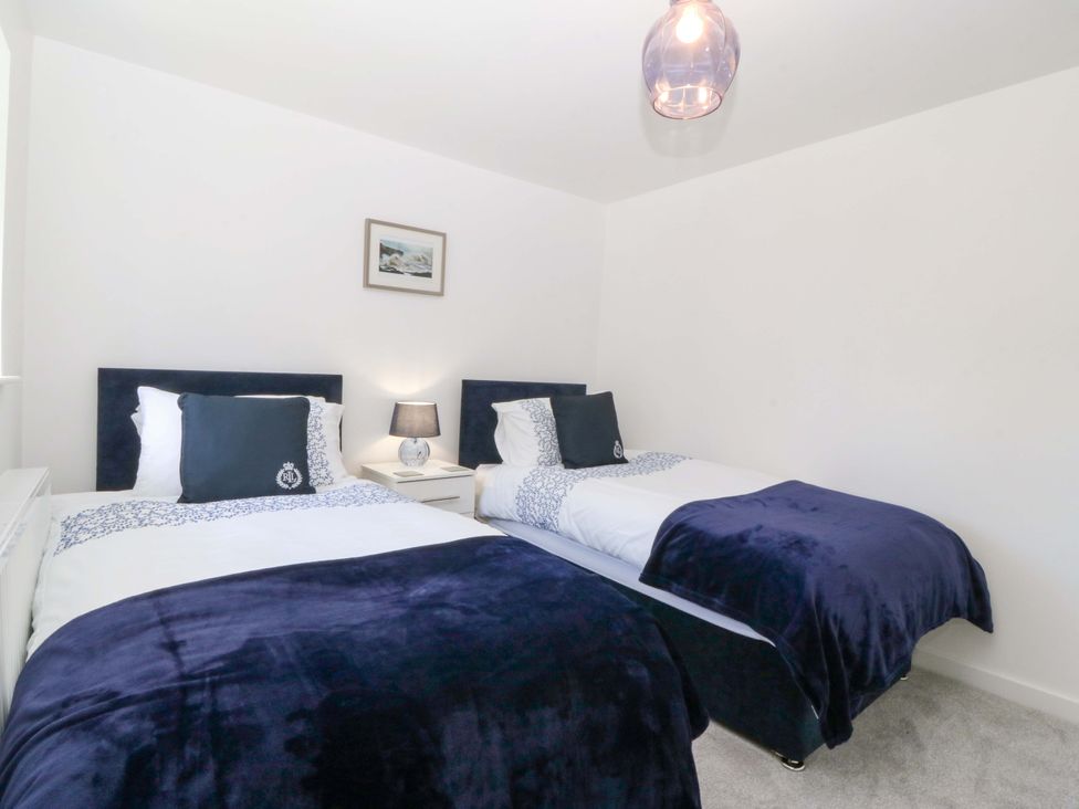 A bedroom with twin beds and a lamp at Cil Y Coed in Star near Llanfairpwllgwyngyll