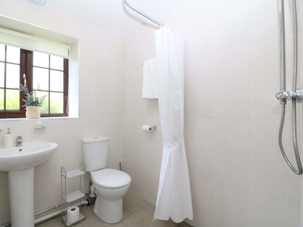 A bathroom featuring a sink, toilet, and shower at Cil Y Coed in Star near Llanfairpwllgwyngyll