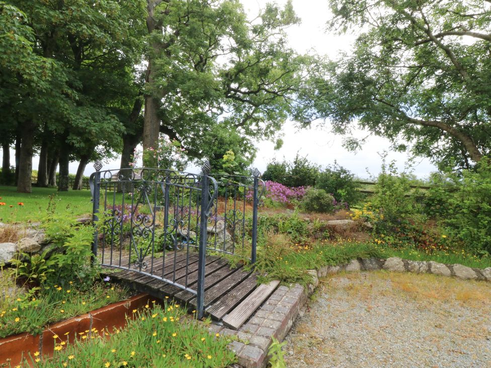 A garden with a bridge and flowers at Cil Y Coed in Star near Llanfairpwllgwyngyll