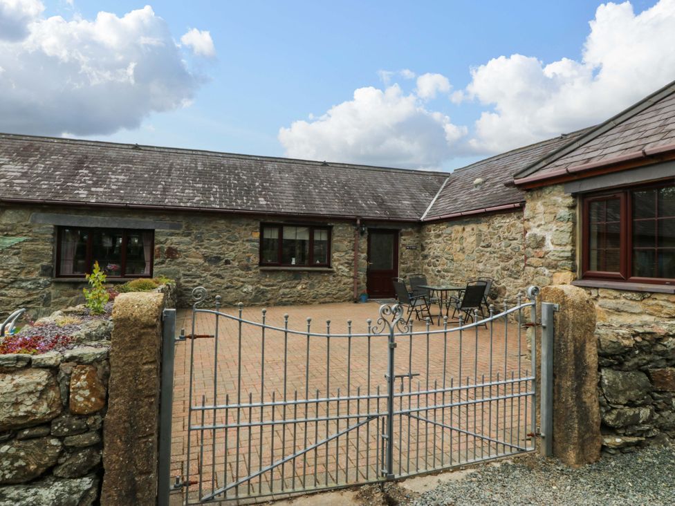 An outdoor area with stone walls and a patio at Cil Y Coed Star near Llanfairpwllgwyngyll