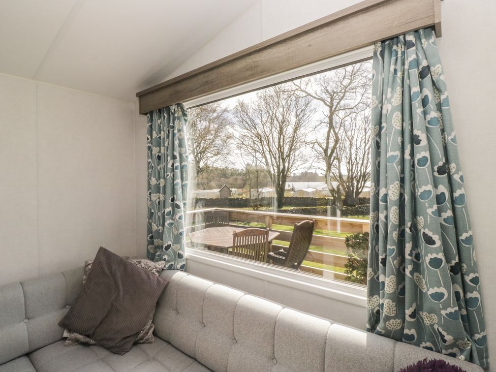 A living room with a sofa and window at Standard Caravan at Three Lochs Holiday Park in Newton Stewart