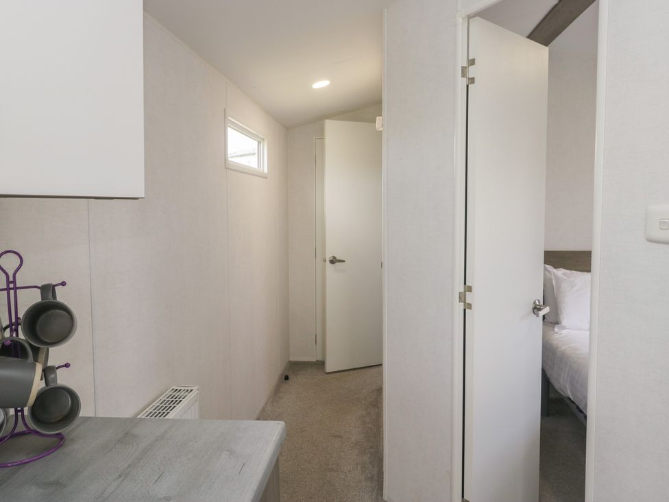 A hallway with doors leading to a bedroom at Standard Caravan at Three Lochs Holiday Park in Newton Stewart