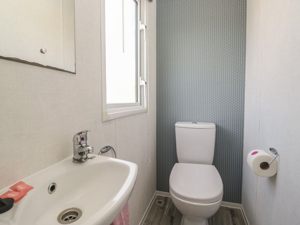 A bathroom with a sink and toilet at Standard Caravan at Three Lochs Holiday Park, Newton Stewart