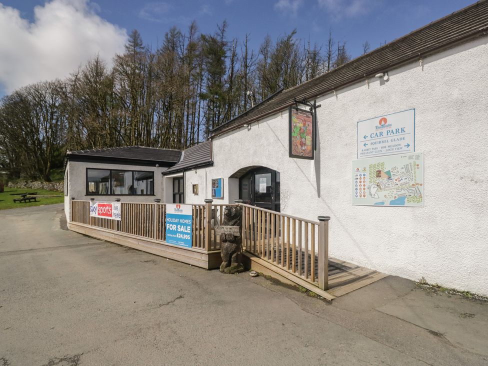 An outdoor area with a building and signs at Standard Caravan at Three Lochs Holiday Park Newton Stewart