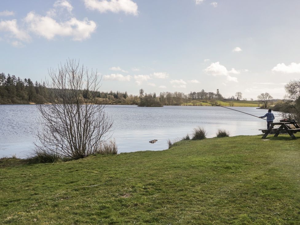 A person fishing by a lake at Standard Caravan at Three Lochs Holiday Park Newton Stewart